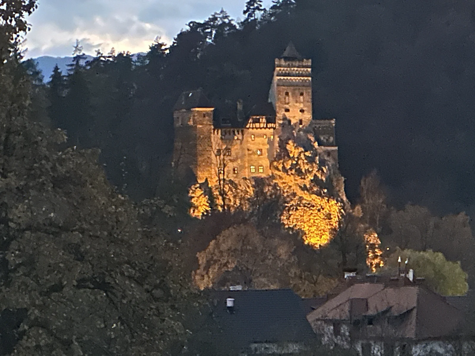 A closer view of Bran Castle illuminated at dusk.